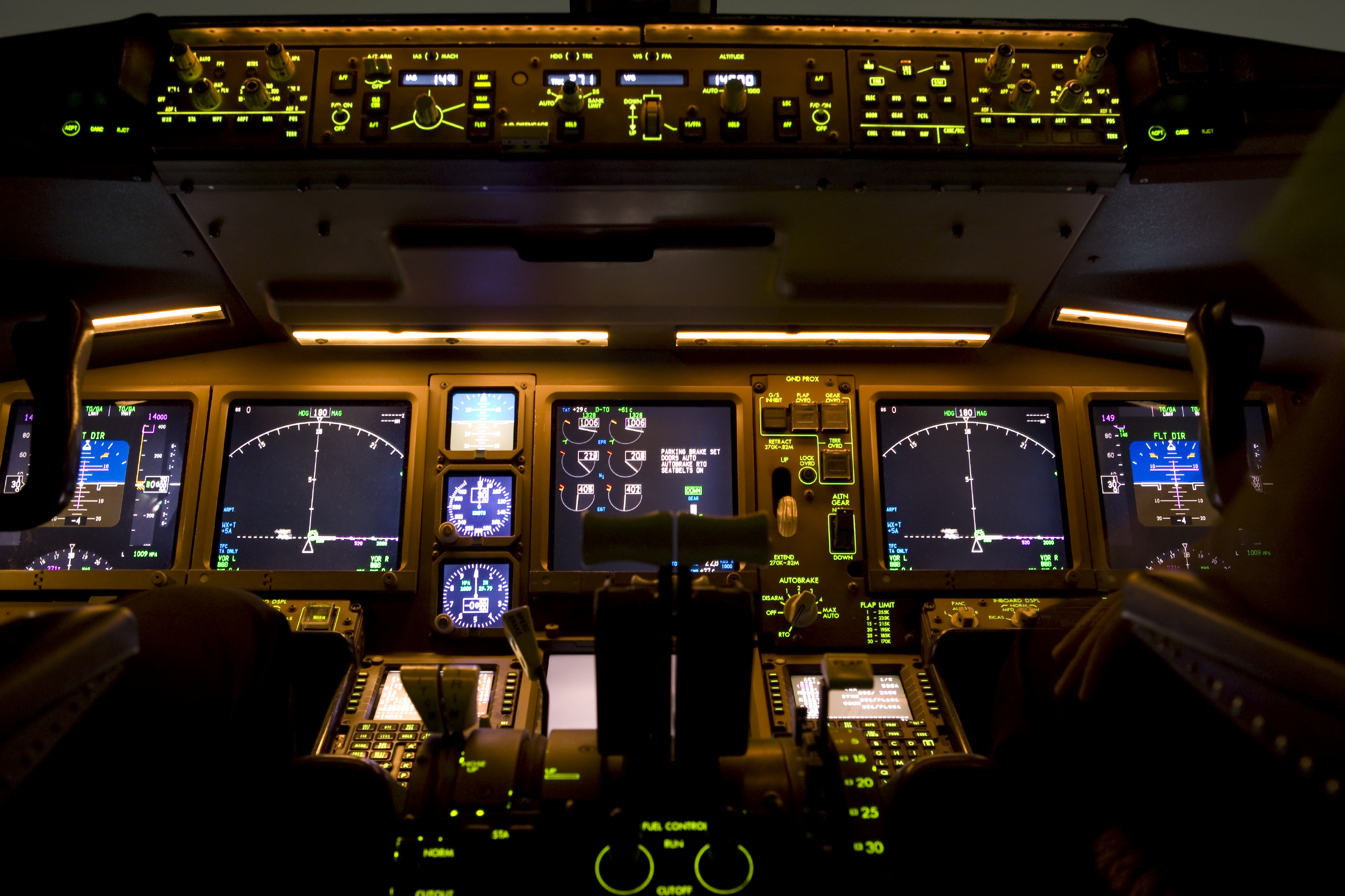 The muted lights of an airline cockpit at night.